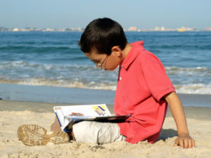 Boy Reading on the Beach
